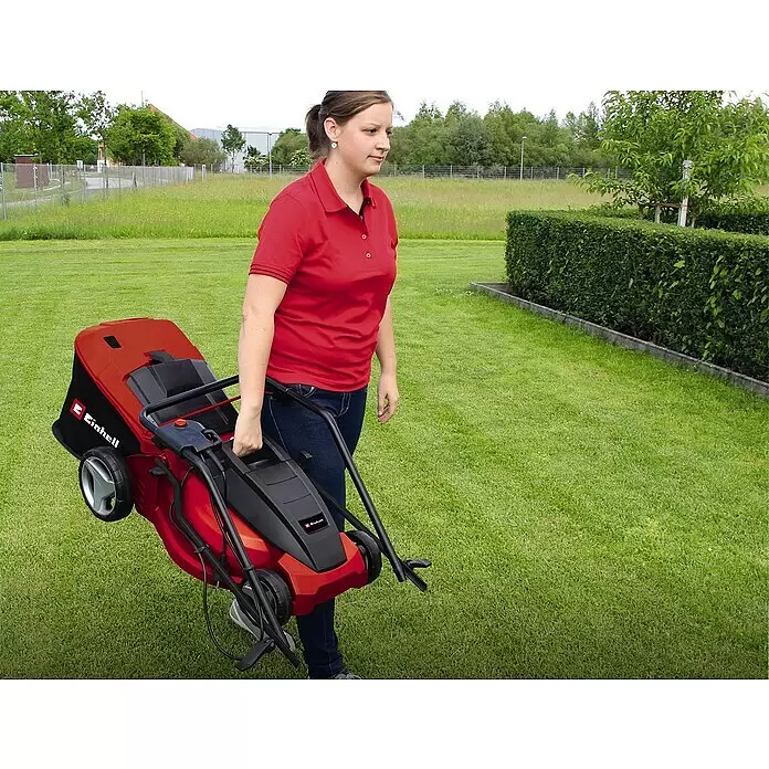 Einhell Elektro-Rasenmäher GC-EM 1742 - 1.700 W, Schnittbreite: 42 cm - Eine Frau trägt einen kompakten rot-schwarzen Einhell Rasenmäher am Griff.