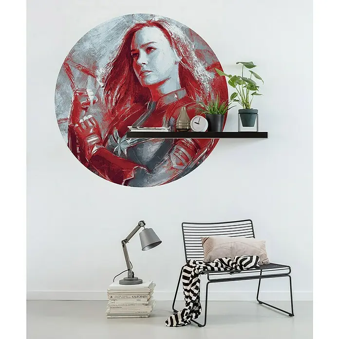 Komar Dots Fototapete rund Avengers Paint Captain Marvel - 125 cm, Selbstklebend - Wanddekoration mit Captain Marvel Motiv. Das Bild ist in Rot- und Grautönen gehalten und befindet sich über einem Regal mit Pflanzen und Dekorationen.