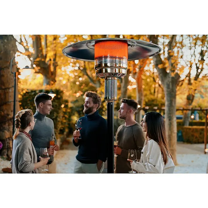 Terrassenstrahler - Höhe: 221 cm, Aluminium - Eine Terrassenheizung spendet Wärme für eine Gruppe von Menschen, die sich im Freien versammelt haben. Herbstliche Stimmung und angenehme Atmosphäre.