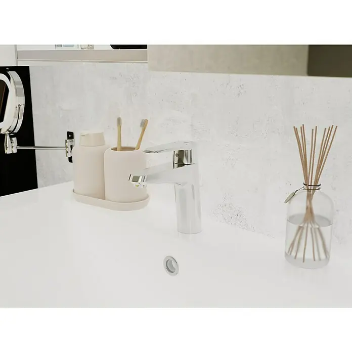 Grohe Eurodisc Cosmopolitan Waschtischarmatur S-Size - 12,5 l/min, Chrom, Glänzend - Nahaufnahme eines Waschbeckens mit Armatur, Seifenspender, Zahnbürsten und Duftstäbchen, die ein sauberes und modernes Badezimmerambiente ausstrahlen.