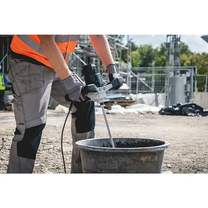 Metabo Rührwerk RWE 1200 - Mischvolumen: 30 l, Durchmesser Rührer: 120 mm - Ein Bauarbeiter mischt mit einem Metabo-Rührwerk Mörtel in einem schwarzen Eimer auf einer Baustelle.
