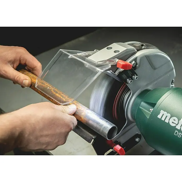 Metabo Elektro-Doppelschleifer DS 150 Plus - 400 W, 2.980 U/min - Metallrohr wird mit einer Metabo DS Schleifmaschine bearbeitet. Die Maschine verfügt über einen Schutzschild für sicheres Arbeiten.