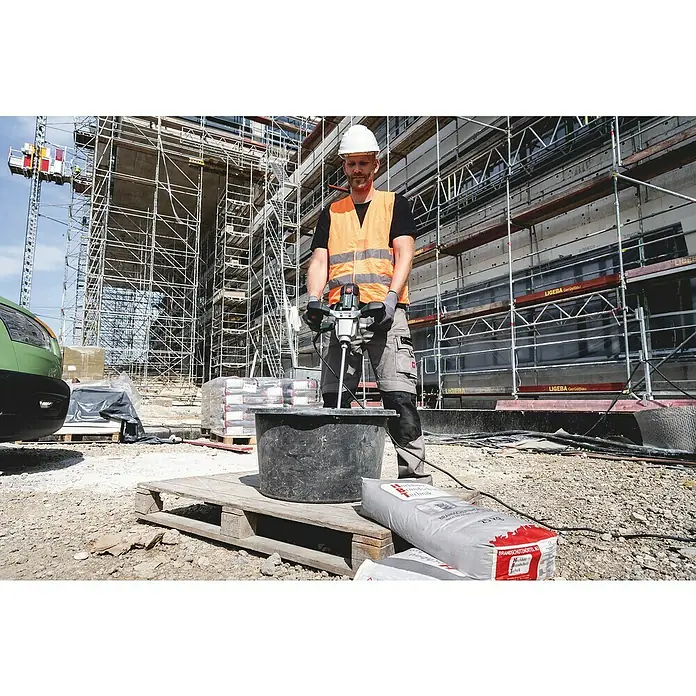 Metabo Rührwerk RWEV 1600-2 - Mischvolumen: 90 l, Durchmesser Rührer: 160 mm - Bauarbeiter mischt Mörtel mit einem elektrischen Mörtelrührer auf einer Baustelle. Schutzkleidung und Baustellenausrüstung sind im Bild zu sehen.