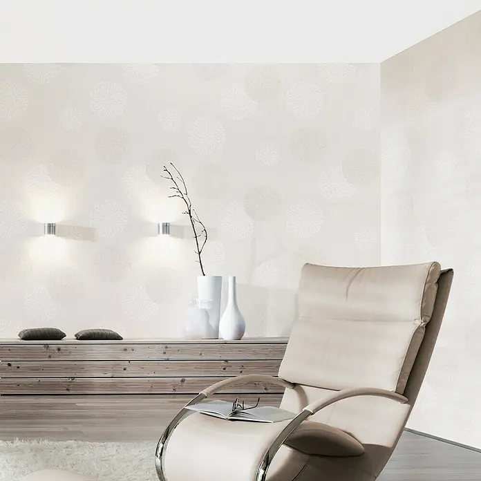 A.S. Création Vliestapete Blütenmuster - Creme/Weiß, Floral, 10,05 x 0,53 m - Wohnzimmer mit elegantem Sessel und stilvoller Wandtapete mit Kreismuster für ein modernes Ambiente.