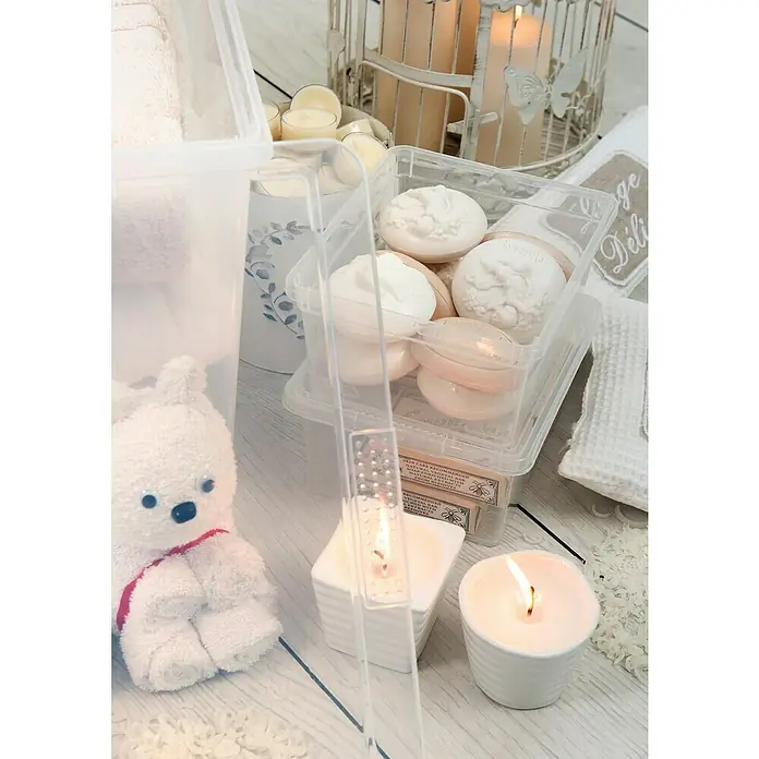 KIS Aufbewahrungsbox C-Box XXS+ - 16,5 x 19,5 x 9,5 cm, 2 l, Transparent - Blick auf eine Sammlung von Kerzen, Seifen und einem Plüschtier, die in durchsichtigen Behältern auf einem hellen Holztisch präsentiert werden.