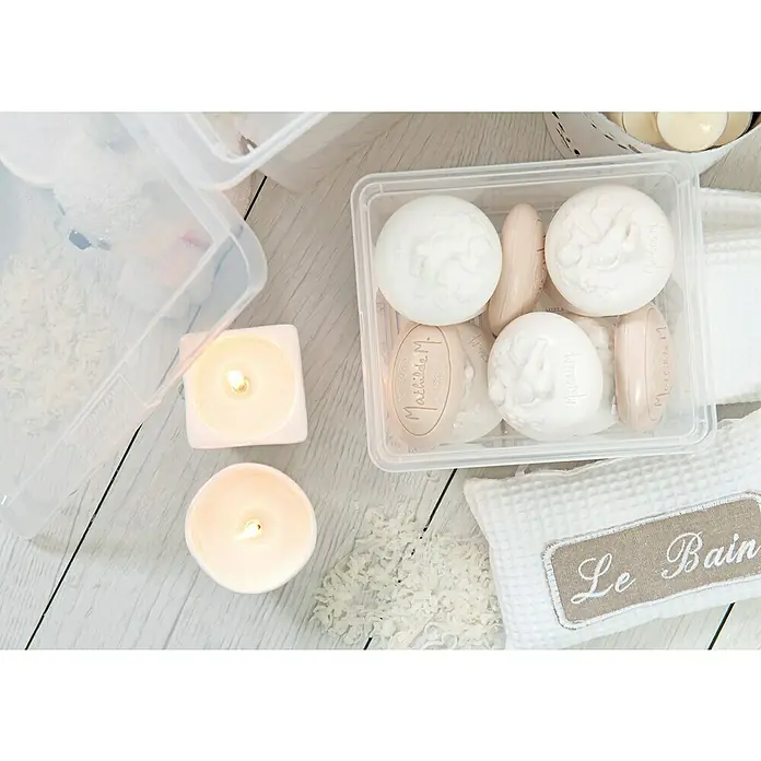 KIS Aufbewahrungsbox C-Box XXS+ - 16,5 x 19,5 x 9,5 cm, 2 l, Transparent - Helle Badezimmer-Szene mit duftenden Seifen in einer transparenten Box, weißen Kerzen und einem Kissen mit der Aufschrift "Le Bain".