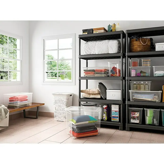 Regalux Clear Box ML x B x H: 54,8 x 38,4 x 18,9 cm, 31 l, Transparent - Ein Wäscheraum mit grauen Aufbewahrungseinheiten, die mit diversen Artikeln gefüllt sind, und klaren Aufbewahrungsboxen auf einer Holzbank und dem Boden.