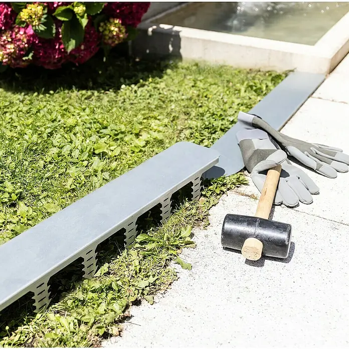 Windhager Mähkante Easymow - 80 x 11 x 7 cm, Silber, Verzinkt - Gartenarbeit: Metallkanten, Gummihammer und Handschuhe liegen bereit zur Installation im Garten für eine saubere Rasenkante.
