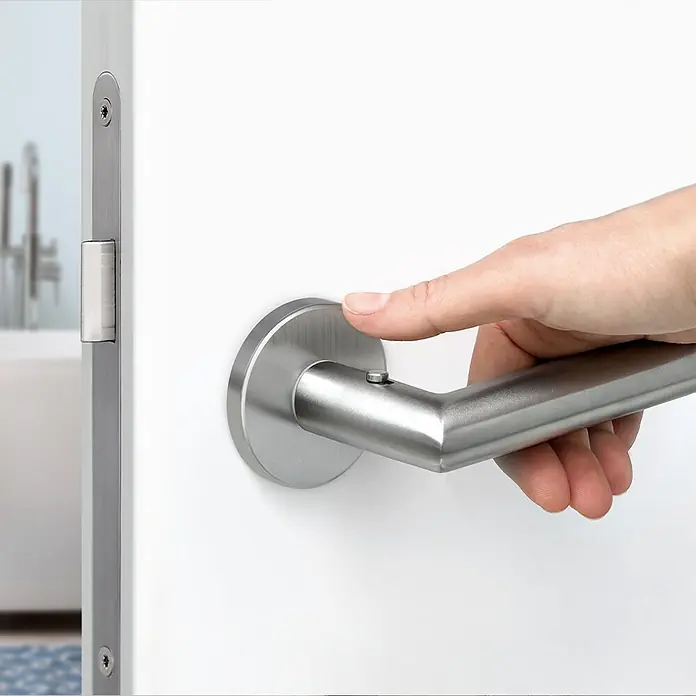 Diamond Doors Zimmertürgarnitur Moderna Smart2lock - Stärke Tür: 38 mm - 45 mm, Edelstahl, L-Form, Edelstahl matt, DIN Anschlag: Rechts, Passend für: Türen ohne Schlüssellochbohrung, Türen mit Schlüssellochbohrung benötigen zusätzlich eine Blindrosette - Eine Hand betätigt einen modernen Türgriff aus Edelstahl an einer weißen Tür. Der Griff hat eine zylindrische Form und ein schlichtes Design.
