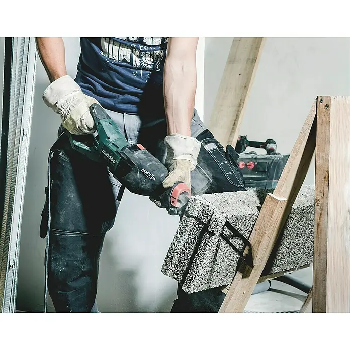 Metabo Säbelsäge SSEP 1400 MVT - 1.400 W, Hublänge: 32 mm - Ein Mann schneidet mit einer Metabo-Säge einen Ziegelstein. Der grüne Metabo-Säge ist gut erkennbar.