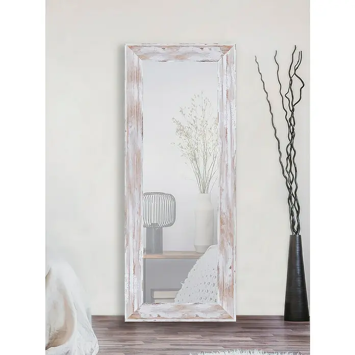 Espejo de pared DM Lisboa - 54 x 144 cm, Blanco decapado - Un espejo rústico de cuerpo entero, encalado, que se encuentra en una habitación luminosa y refleja elementos decorativos.