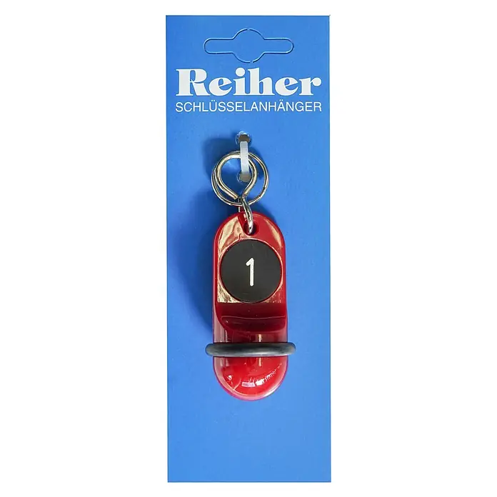 Reiher Schlüsselanhänger Junior Nr. 1 - Länge: 60 mm - Ein roter Reiher Schlüsselanhänger mit der Nummer 1 auf blauem Hintergrund, verpackt und zum Verkauf bereit.