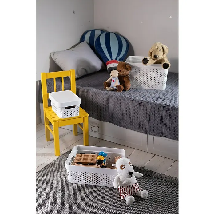 Curver Aufbewahrungsbox Infinity - L x B x H: 35,6 x 26,6 x 13,6 cm, Kunststoff, Weiß - Nahaufnahme von Kunststoff-Aufbewahrungsboxen mit Löchern in einem Kinderzimmer, mit Spielzeug und einem gelben Stuhl.
