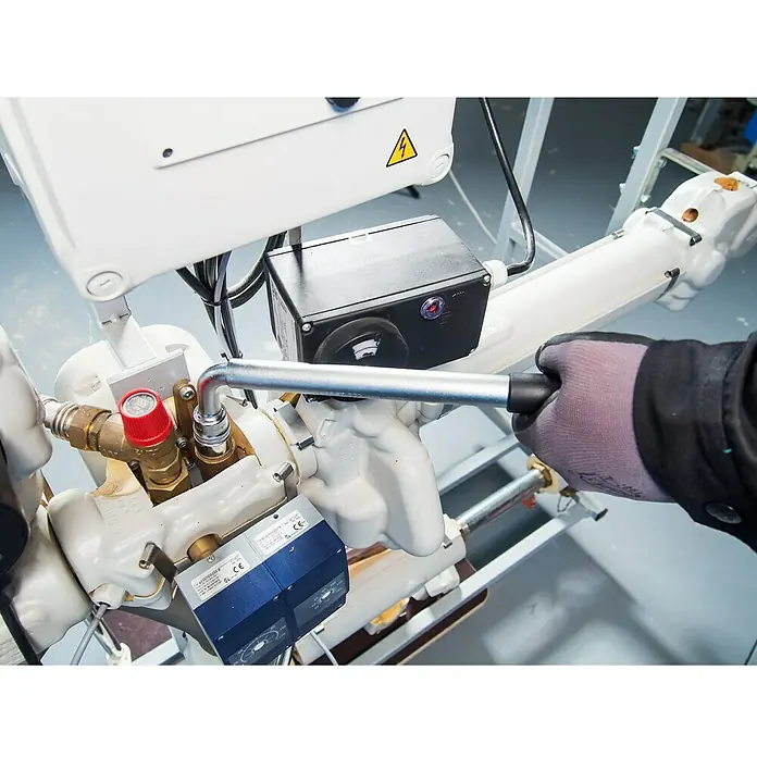 Hazet Teleskop-Radmutternschlüssel 772 - Teleskopierbar: 303 mm - 535 mm, Antriebsgröße: ½″ - Nahaufnahme einer Person, die ein Werkzeug an einer weißen Industriemaschine mit elektronischen Komponenten verwendet.