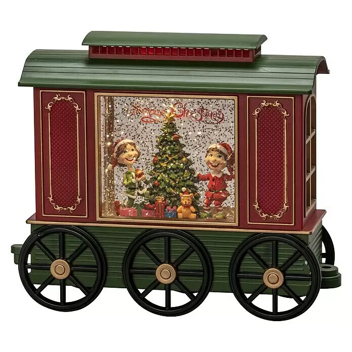 Konstsmide LED-Schneelaterne Wagon - Innen, Mehrfarbig, 24 x 9 x 19,5 cm, Wagon mit Christbaum, Batteriebetrieben - Eine grün-rote Weihnachtszugwagendekoration mit drei Rädern, die eine Innenszene mit Elfen, einem Weihnachtsbaum und Glitzer mit "Merry Christmas"-Text zeigt.