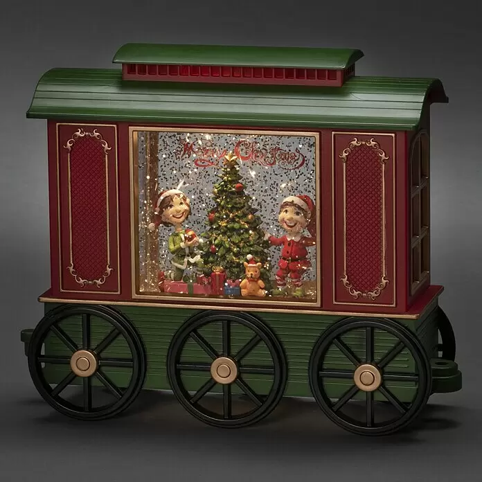 Konstsmide LED-Schneelaterne Wagon - Innen, Mehrfarbig, 24 x 9 x 19,5 cm, Wagon mit Christbaum, Batteriebetrieben - Festliche rot-grüne Weihnachtszug-Deko mit Elfen, Baum, Geschenken und Glitzer im Fenster, schwarzen Rädern und "Merry Christmas" Schrift.