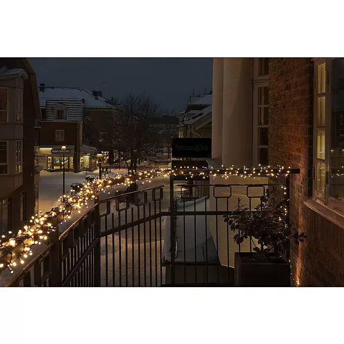 Konstsmide LED-Lichterkette - Außen, Lichtfarbe: Warmweiß, Anzahl Leuchtmittel: 400 Stk., Netzbetrieben - Warmweiße Lichterkette beleuchtet ein Metallbalkongeländer in einer verschneiten Winternacht.