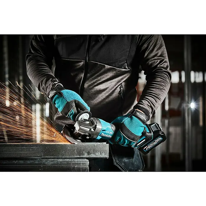 Makita XGT 40V max. Akku-Winkelschleifer GA013GZ - Ohne Akku, Leerlaufdrehzahl: 8.500 U/min - Makita Akku-Winkelschleifer im Einsatz mit schützenden Handschuhen, Funken fliegen beim Schleifen.