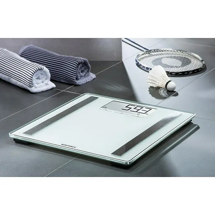 Báscula digital Shape Sense Control 200 - 32 x 32 x 2,1 cm, Vidrio, Blanco - Báscula de baño digital de vidrio con toallas y un juego de bádminton al fondo.