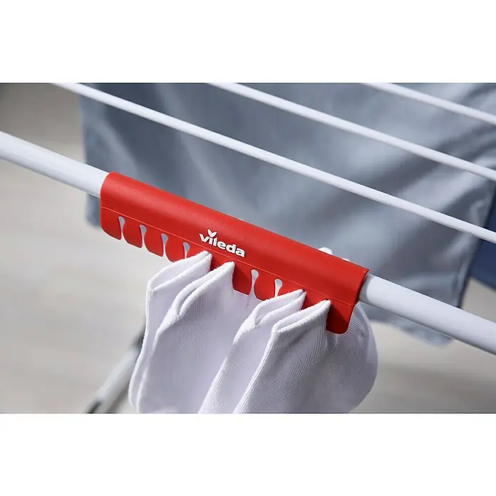 Vileda Flügel-Wäscheständer King - Länge Wäscheleine: 20 m, Weiß/Schwarz - Nahaufnahme eines Vileda Wäscheständers mit roten Sockenhaltern und weißen Socken, ideal zum Trocknen kleiner Wäschestücke.
