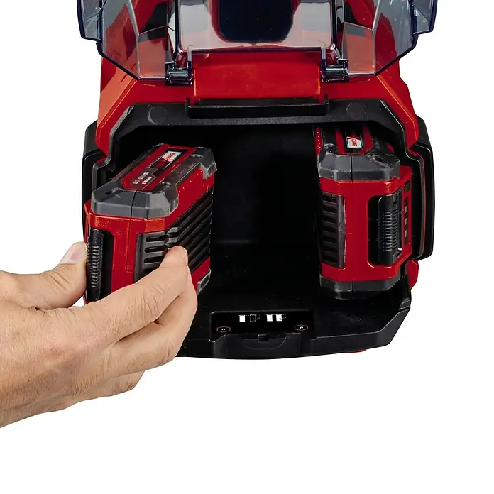 Einhell Power X-Change 18V Akku-Gartenpumpe AQUINNA 18/30 F LED - 18 V, Ohne Akku, Max. Fördermenge: 3.000 l/h - Akku-Ladegerät mit zwei roten Akkus, einer wird gerade von einer Hand eingesetzt. Das Ladegerät ist rot und schwarz.