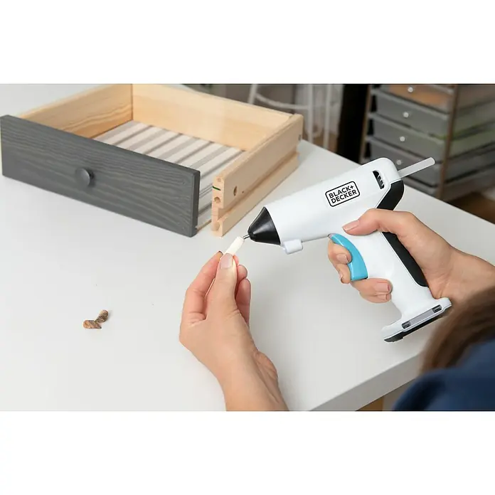 Black+Decker Pistola termoencoladora con batería BCGL115 3,6V-Li - 3,6 V - La pistola de pegamento caliente Black+Decker se está utilizando para unir un elemento de madera a una parte de cajón sin terminar.