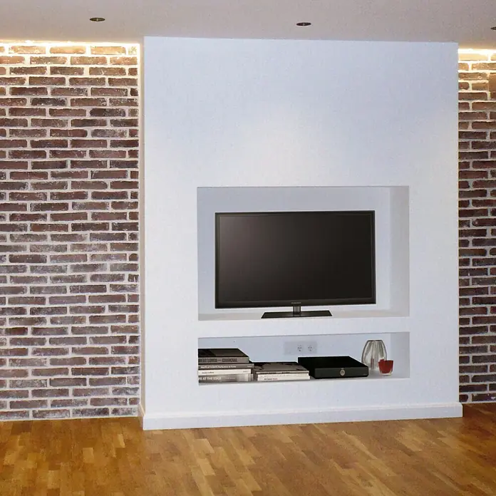 Revestimiento de piedra Mediterráneo Teja - 24 x 5,5 x 2,5 cm - Un elegante salón con una moderna pared multimedia blanca que alberga un televisor y objetos decorativos.
