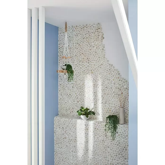 Mosaikfliese Kiesel XKF 006M - 30,5 x 30,5 cm, Weiß, Matt - Helle Kieselstein-Mosaikfliesen bedecken eine Wand und ein eingebautes Regal in einem naturinspirierten Raum.