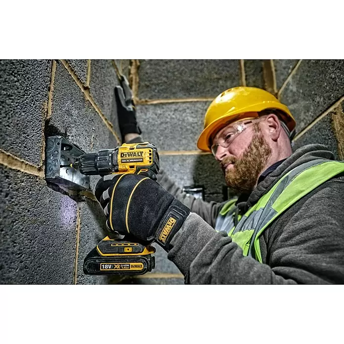 DeWalt XR 18V Akku-Bohrschrauber DCD708N-XJ - 18 V, Ohne Akku, 65 Nm - Mann benutzt gelb-schwarzen DeWalt Akkubohrschrauber zum Befestigen einer Metallhalterung an einer Mauer.