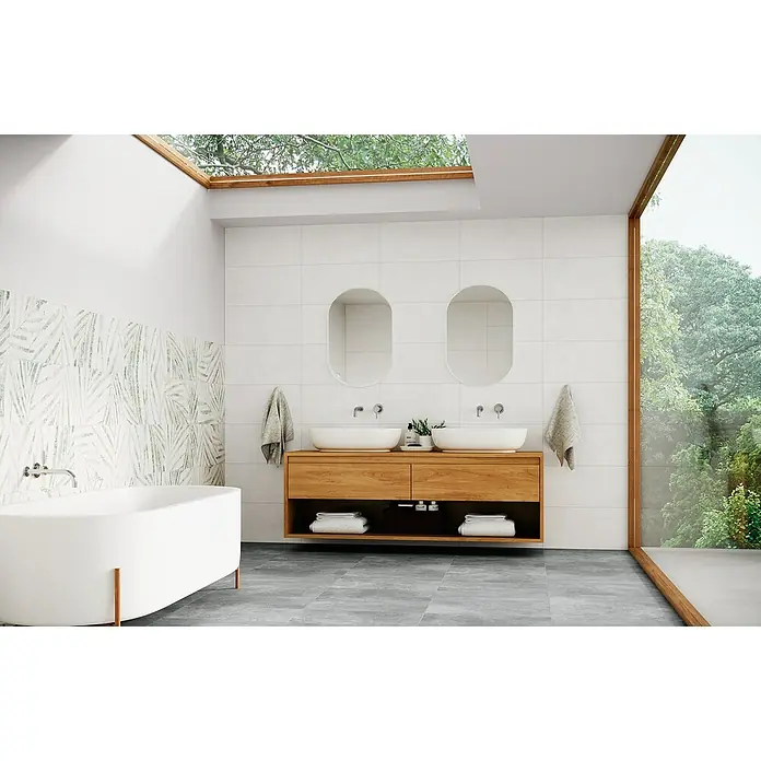 Domicil Wandfliese Living Concrete - 30 x 60 cm, Weiß, Matt - Helles Badezimmer mit freistehender Badewanne, Waschtisch mit zwei Waschbecken und großem Fenster für natürliches Licht.