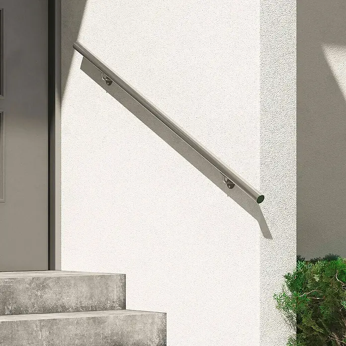 Dolle Handlauf-Set PS 502 - Edelstahl V2A, Silber, Länge: 150 cm - Bild einer grauen Treppe mit einem stilvollen Edelstahl-Handlauf, der an einer weißen Wand befestigt ist und für Sicherheit sorgt.