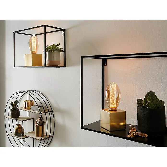 Paulmann Bombilla LED Paulmann Vintage Anillo - E27, No regulable, Blanco cálido, 230 lm, 4 W, Gota - Primer plano de estanterías de pared con objetos decorativos como una lámpara dorada y plantas, creando un ambiente moderno en el hogar.