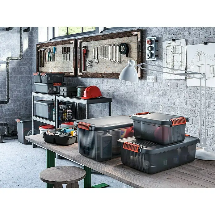 KIS Aufbewahrungsbox K LATCH - L x B x H: 39 x 29 x 18 cm, Grau - Werkstatt-Szene mit Werkzeugkisten, Werkzeugen an der Wand und einer Werkbank mit Hocker, ideal für Heimwerker und Handwerker.