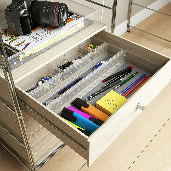 Sistemo Schubladeneinsatz - 30 x 7,5 x 5 cm, Transparent, Kunststoff - Aufnahme eines Schubladensets mit Kamera und Magazinen obenauf, das verschiedene Büroartikel wie Stifte und Textmarker enthält.
