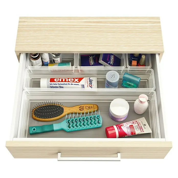 Sistemo Schubladeneinsatz - 22,5 x 7,5 x 5 cm, Transparent, Kunststoff - Ein offener Badezimmerschrank mit verschiedenen Kosmetikprodukten wie Cremes, Bürsten und Zahnpasta in durchsichtigen Behältern.