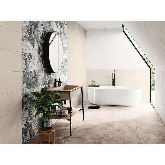 Domicil Feinsteinzeugfliese Stone Art - 60 x 60 cm, Caramel Beige, Matt - Stilvolles Badezimmer mit ovalem Spiegel, modernem Waschtisch und freistehender Badewanne unter einem Dachfenster für entspannende Momente.