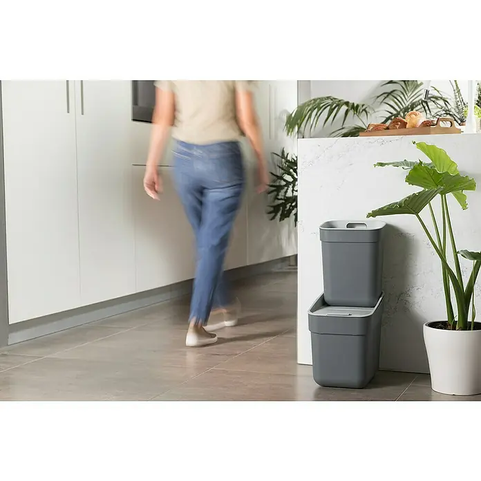 Curver Standard Mülleimer Ready to Collect - 10 l, Kunststoff, Dunkelgrau - Grauer, stapelbarer Küchenabfallbehälter aus Kunststoff neben einer Zimmerpflanze, ideal für die Mülltrennung in der Küche.