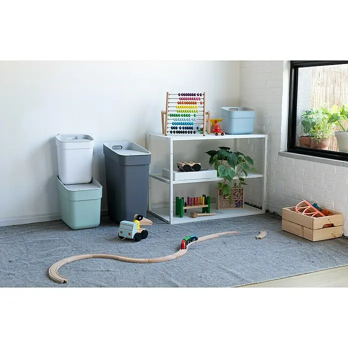Curver Standard Mülleimer Ready to Collect - 30 l, Kunststoff, Dunkelgrau - Ein Spielzimmer mit Spielzeug auf einem grauen Teppich, darunter Mülleimer, ein Regal mit einem Abakus und eine Holzkiste mit Spielzeug.