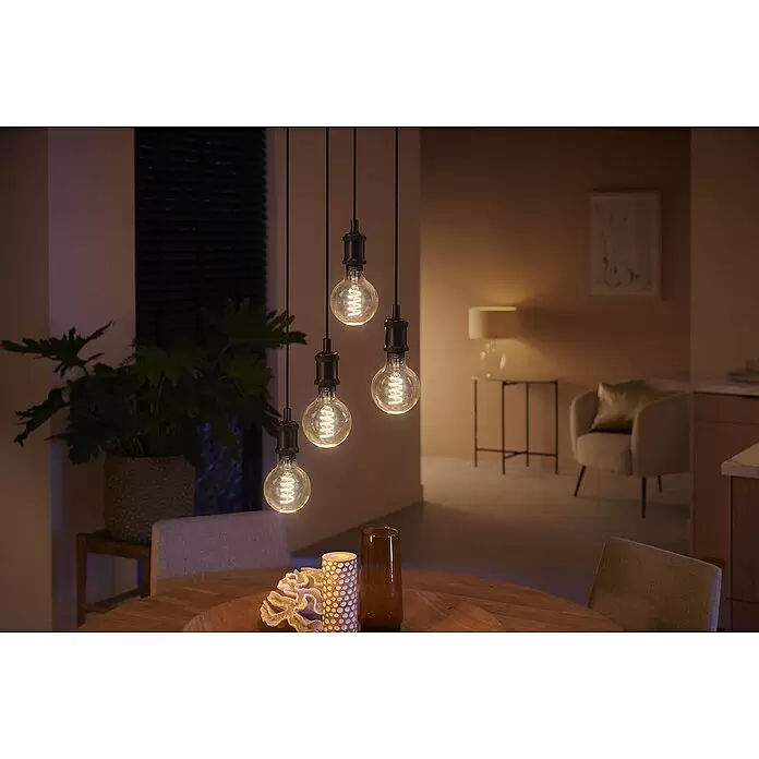 Philips Hue Smart-LED-Lampe White Ambiance Filament - E27, Dimmbar, Warmweiß, 550 lm, 7 W, Lampenbezeichnung: G93, 1 Stk. - Fünf Pendelleuchten mit Spiralfaden erhellen einen Essbereich mit warmem Licht.