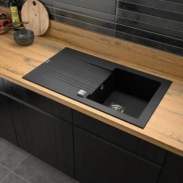 Carea Einbauspüle Muscade - 86 x 50 cm, Schwarz - Schwarze Spüle aus Verbundmaterial auf einer Holzarbeitsplatte mit passendem Küchenschrank.