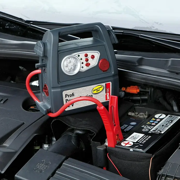 UniTEC Energiestation - Ausgangsspannung: 12 V, Akkutyp: Li-Ionen - Profi Power Station 12V, ein tragbarer Akku-Booster mit rotem Kabel, der an die Autobatterie angeschlossen ist.