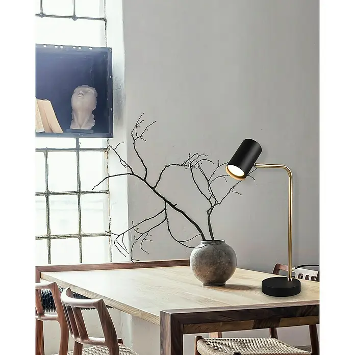 Trio Lighting Marley Lámpara de sobremesa redonda - 5 W, Dorado/Negro, GU10 - Elegante lámpara de mesa negra y dorada sobre una mesa de madera, creando un ambiente cálido. Perfecta para interiores elegantes.