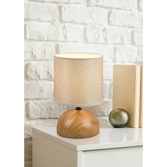 Trio Lighting Lámpara de sobremesa Luci - 40 W, Ø x Al: 14 x 23 cm, Beige, E14 - Primer plano de una lámpara de noche con base de madera y pantalla de tela sobre una mesita blanca con una pequeña esfera al lado.