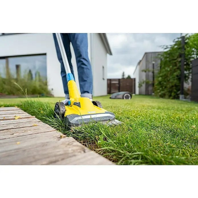 Gloria Power for All 18V Akku-Rasenmäher Grasschere FineCut 18V - 18 V, 1 Akku, Schnittbreite: 25 cm - Ein gelber Rasenkantenschneider in Aktion, der Rasen trimmt. Im Hintergrund ein Rasenmähroboter.