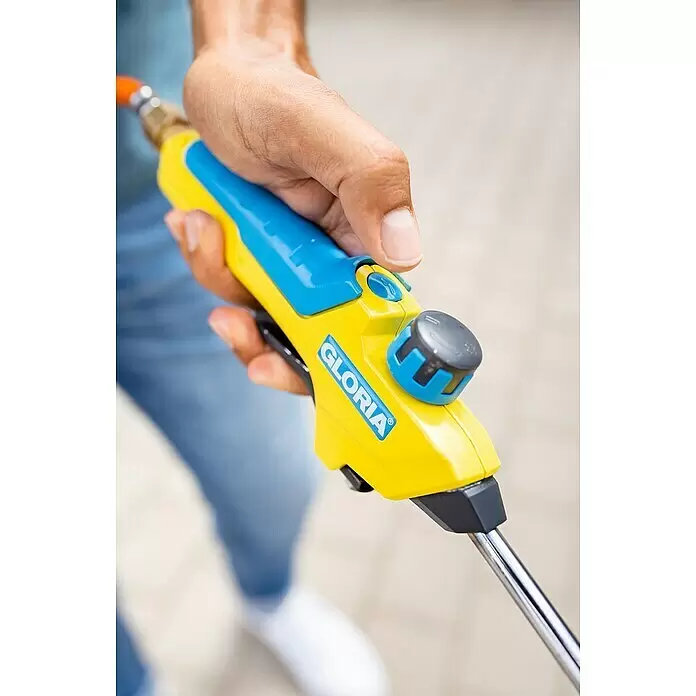Gloria Unkrautvernichter Professional E+ Turbo - Flammtemperatur: 1.200 °C, Automatik - Eine Hand hält eine gelb-blaue GLORIA Sprühlanze, bereit für den Einsatz im Freien.