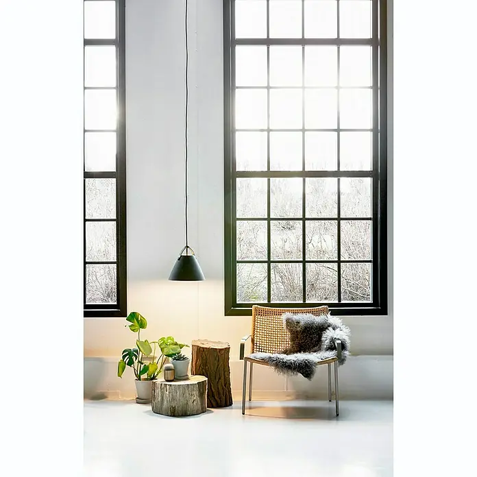 Nordlux Strap Lámpara colgante redonda - 60 W, Ø x Al: 36 x 37 cm, Negro, E27 - Elegante lámpara colgante negra sobre un interior minimalista con taburete de madera, plantas y una silla elegante con manta de piel.