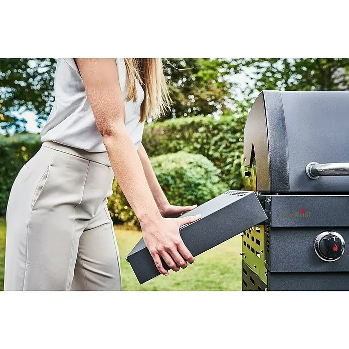 Char-Broil Gasgrill Professional Power Edition 2 - Grillfläche (B x T): 47,8 x 44,5 cm, 6,15 kW, Anzahl Brenner: 2 Stk. - Eine Frau setzt einen Holzkohleeinsatz in einen Char-Broil-Grill ein, um ein optimales Grillerlebnis zu gewährleisten.