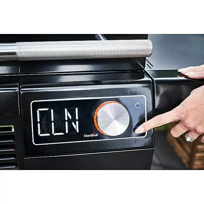 Char-Broil Elektrogrill Smart E - Grillfläche (B x T): 57 x 39 cm, 2,4 kW - Nahaufnahme einer schwarzen Grill-Bedienkonsole mit digitaler Anzeige, silbernem Drehknopf und Tasten. Eine Hand drückt einen blau beleuchteten Knopf.