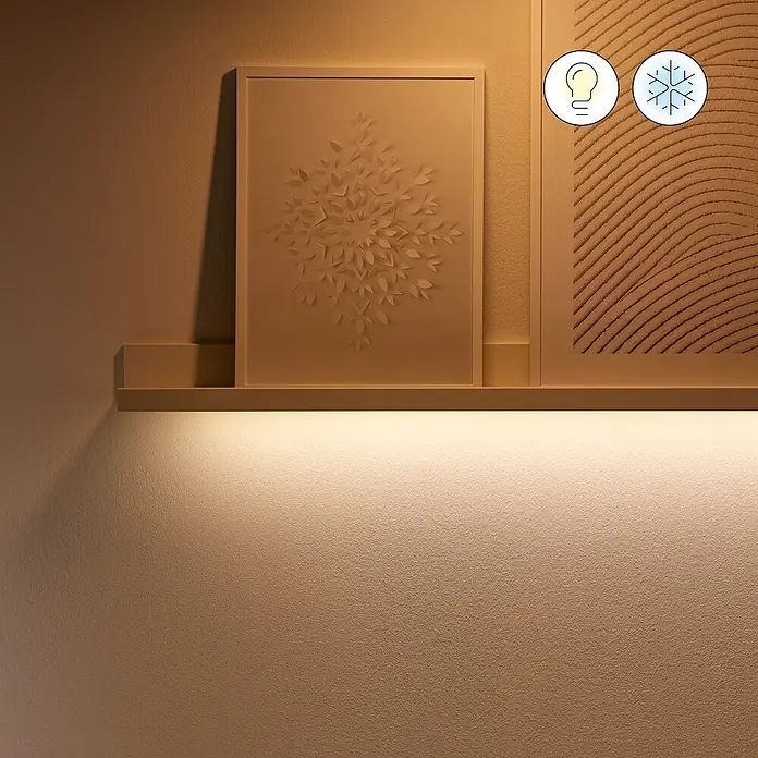 Philips Wiz Smart-LED-Band Startkit - Länge: 4 m, RGBW, 13 W, 840 lm, 220 V - 240 V - Wandregal mit LED-Beleuchtung, auf dem gerahmte Kunstwerke stehen. Warmes Licht betont die Texturen und schafft eine gemütliche Atmosphäre.