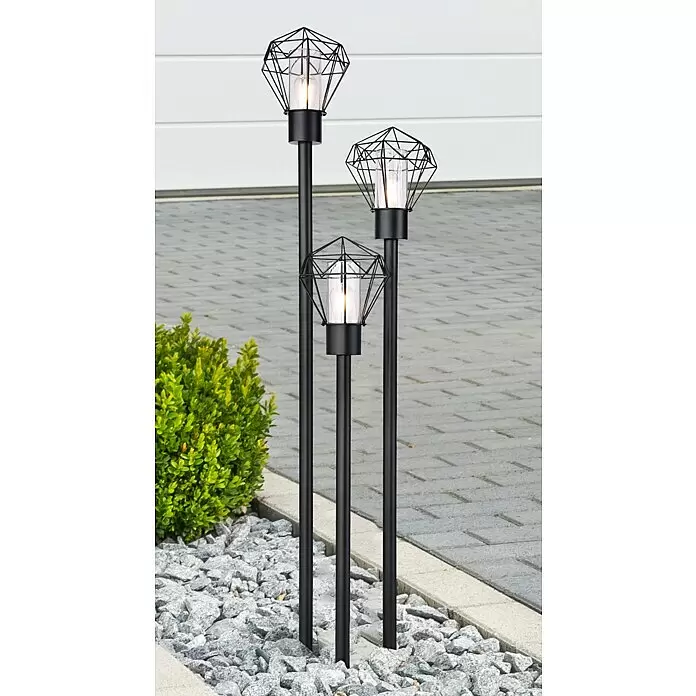 Globo Horace Außenstehleuchte - 45 W, Farbe Gehäuse: Schwarz, 44,2 x 44,5 x 170 cm, Ohne Leuchtmittel - Drei schwarze Metall-Wegeleuchten mit geometrischen Käfigdesigns und warmen LED-Lampen, im Kies neben einer gepflasterten Auffahrt stehend.